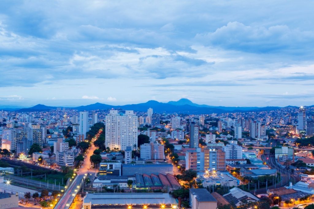 Vista da cidade de Belo Horizonte no fim da tarde. É possível ver as montanhas na distância. Contrate um seguro auto em Belo Horizonte!